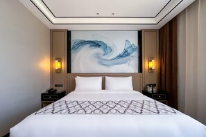 A hotel room with a large bed, two bedside tables, a wall-mounted artwork, and two wall sconces. - Grand Madison Jingzhong Yuci Haitangwan (Jinzhong)