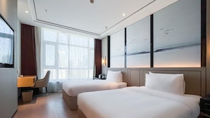 A hotel room with two beds, a desk, and a large window with a view of birds. - Grand Madison Jingzhong Yuci Haitangwan (Jinzhong)