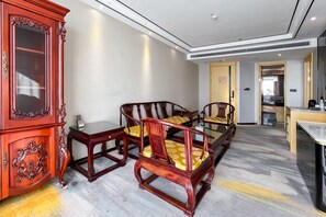 A hotel room with a traditional wooden cabinet, a dining table with chairs, and a modern kitchen area in the background. - Grand Madison Jingzhong Yuci Haitangwan (Jinzhong)