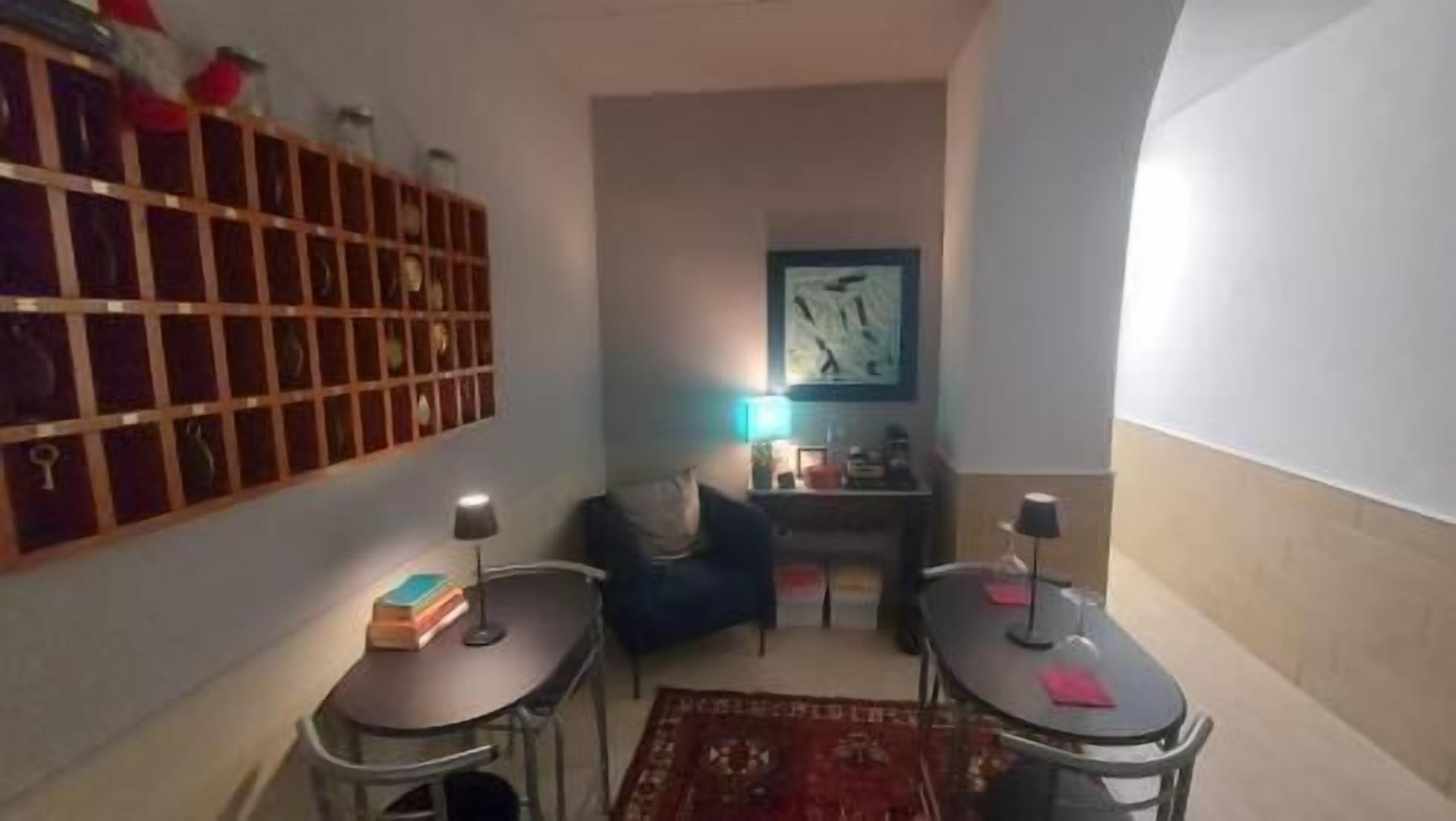 A compact living space with a bookshelf, a desk, a chair, and a small rug.