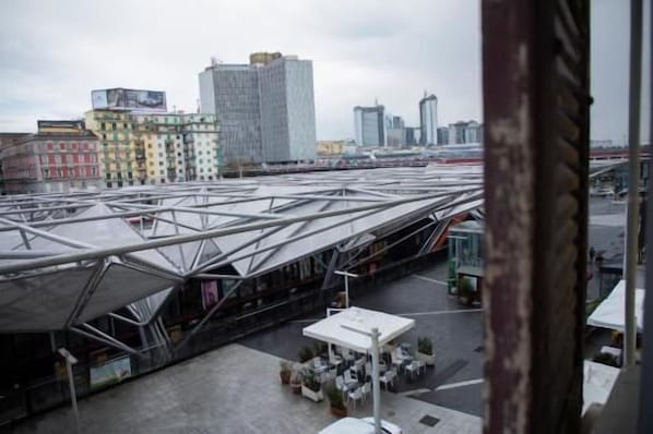 A modern building with a unique roof structure, surrounded by urban buildings.