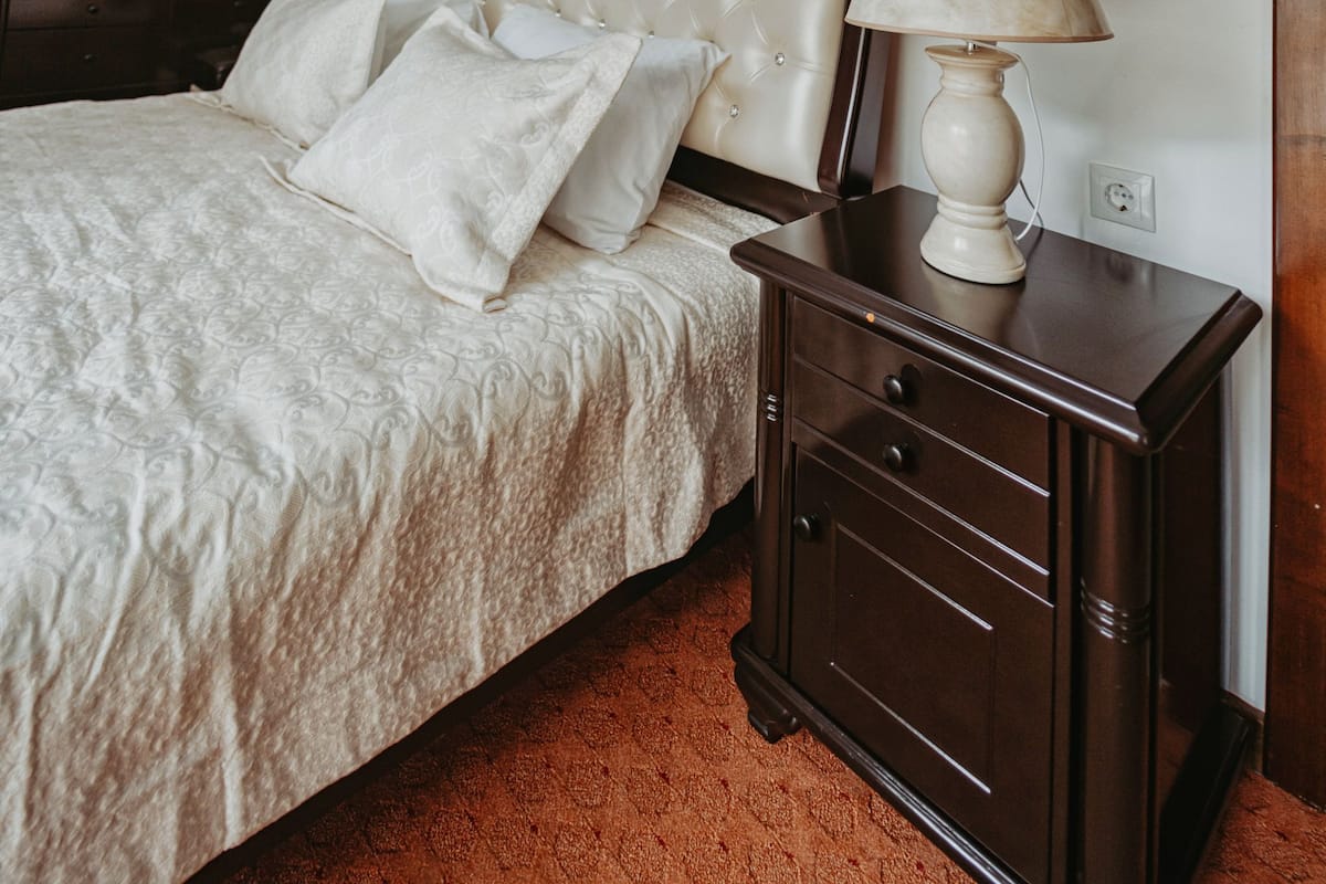 Une chambre à coucher avec un lit, des tables de chevet, une commode, un miroir et un tableau accroché au mur.