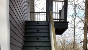 A wooden staircase with a handrail leading to a porch. - Secluded in The Woods (Dana)