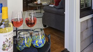 A dining area with a table set for four, featuring a bottle of wine and four glasses. - Oceanside - Dog Friendly - 3pm Checkout   (Pacific Beach)
