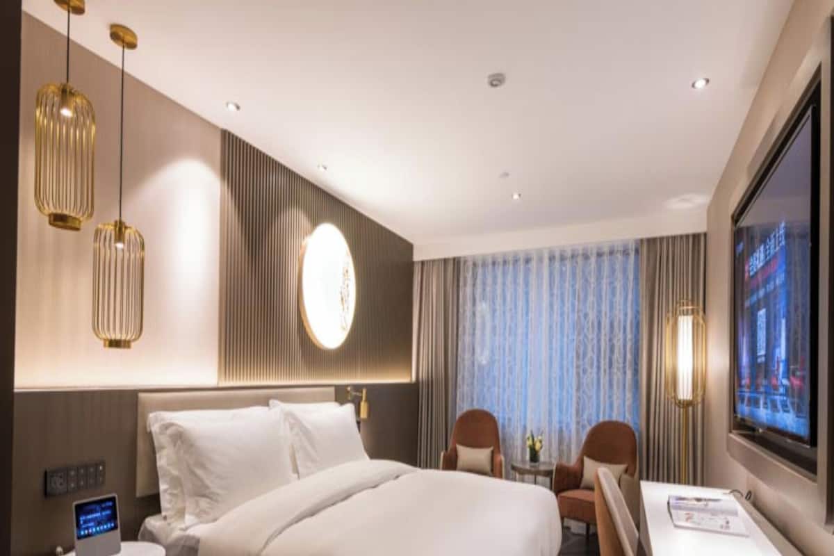 Een hotelkamer met een groot bed, nachtkastjes, een bureau en een televisie.