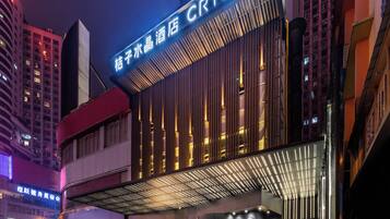 Un hotel con un llamativo letrero 'CRYSTAL', arquitectura moderna y una entrada bien iluminada.