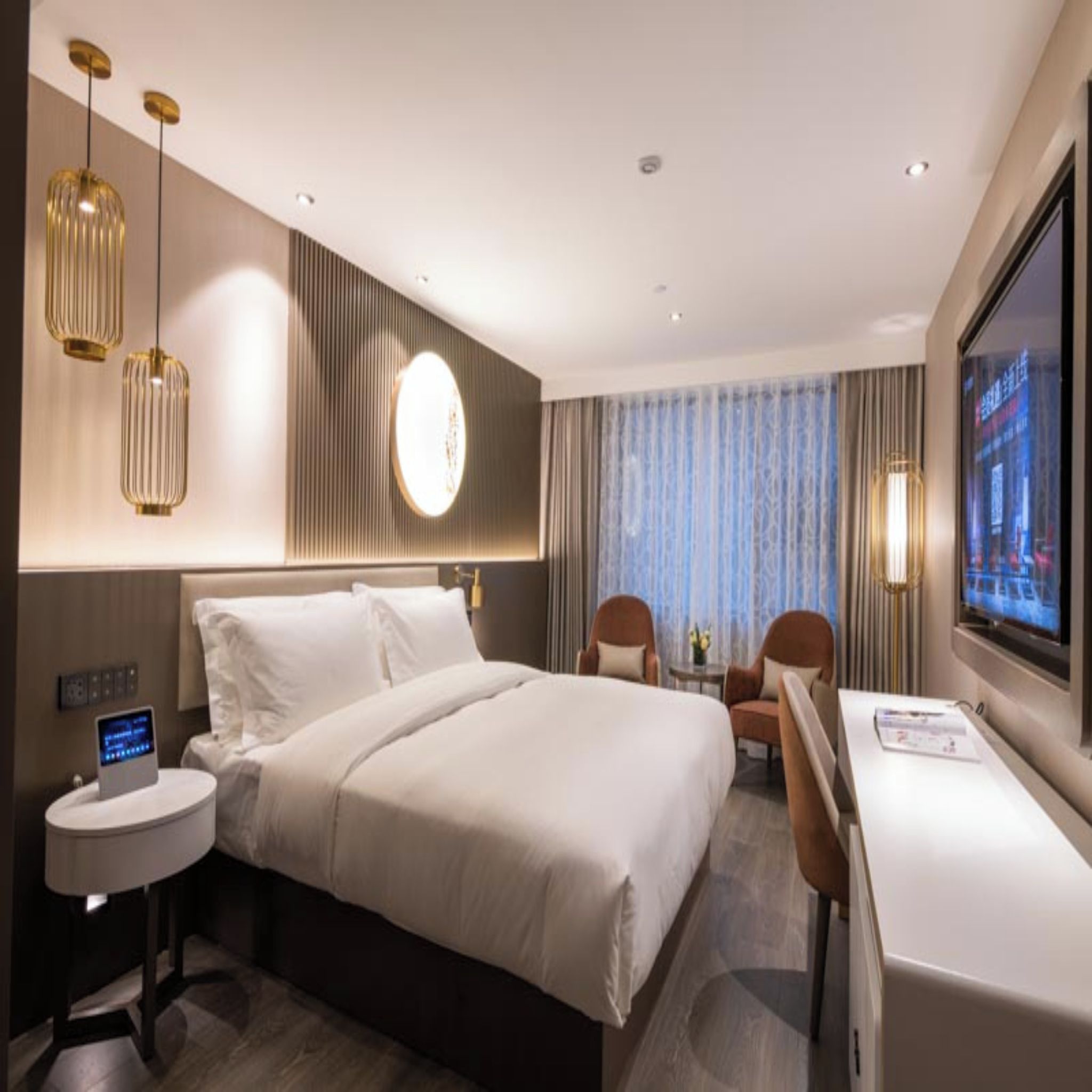 Una habitación de hotel con una cama grande, mesitas de noche, un escritorio y un televisor.