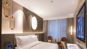 Een hotelkamer met een groot bed, nachtkastjes, een bureau en een televisie.