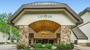 A hotel entrance with a stone facade, a wooden arch, and a chandelier. - Liftside 3BR ~Unit C42~ Ski-in-Ski-out Chair #20 (Vail)