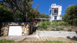 A modern two-story building with a stone wall and a garage.