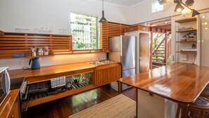 A modern kitchen with wooden cabinetry, a stainless steel refrigerator, and a built-in dishwasher.