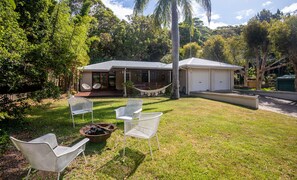 Uma casa com varanda coberta, espaço para churrasco e garagem.