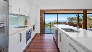 A modern kitchen with a view of the ocean. - This architect-designed Straddie beauty is the perfect laid-back beach house (Point Lookout)