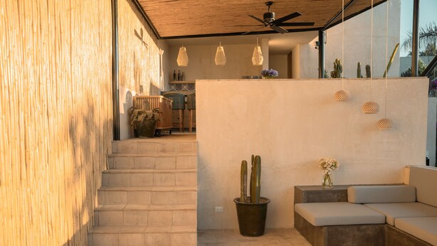Ein modernes Interieur mit Treppe, einer Sitzecke und Pendelleuchten.