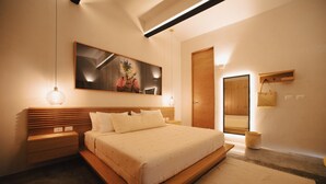 Ein modernes Schlafzimmer mit einem großen Bett, einem Holzkopfende, Nachttischen, einer hängenden Leuchte, einem gerahmten Kunstwerk über dem Bett und einem Holzschrank.