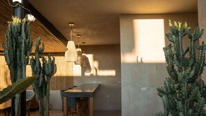 Ein modernes Interieur mit Essbereich, Kakteen und hängenden Pendelleuchten.