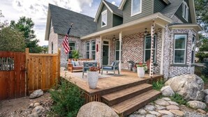 A two-story house with a brick exterior, a wooden deck, and a front porch. - The Isabella House: Historical, Beautifully Renovated, Walkable to Main Street

 (Buena Vista)