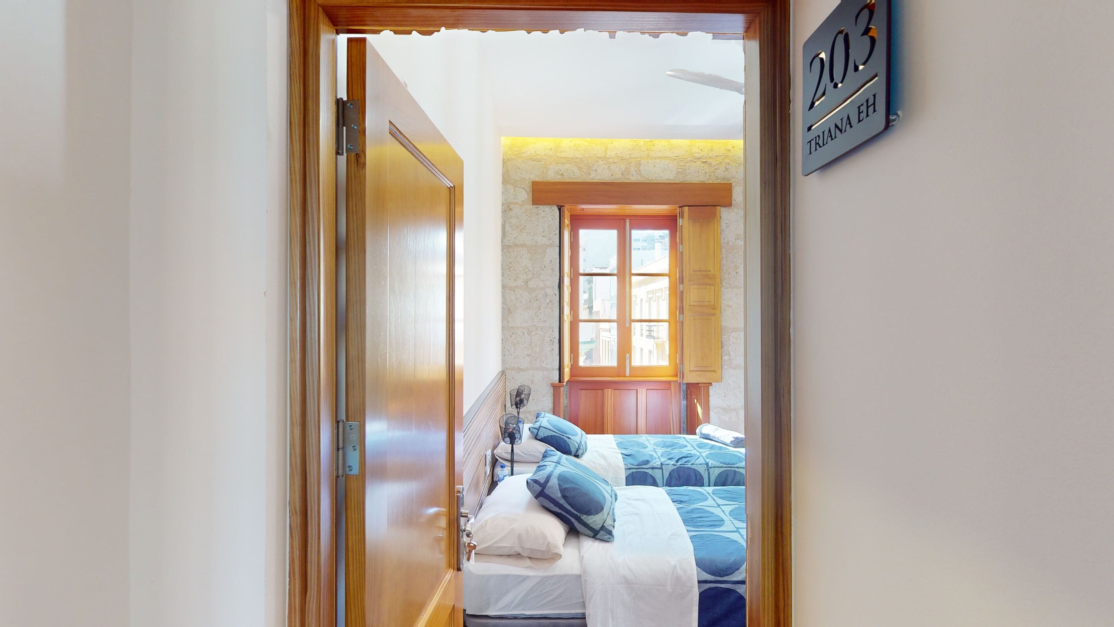 Un dormitorio con una cama, una ventana y una puerta.