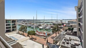 A marina with boats docked, a clear sky, and buildings in the background. - Stunning Auckland Harbour Views (Auckland)
