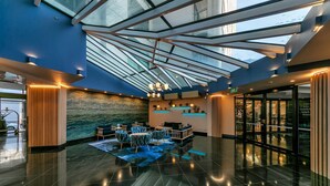 A modern lobby with a glass ceiling, a reception desk, and seating area. - Stunning Auckland Harbour Views (Auckland)