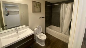 Ein Badezimmer mit einem weißen Waschbecken, einer Toilette, einer Badewanne und einer Duschvorhang.