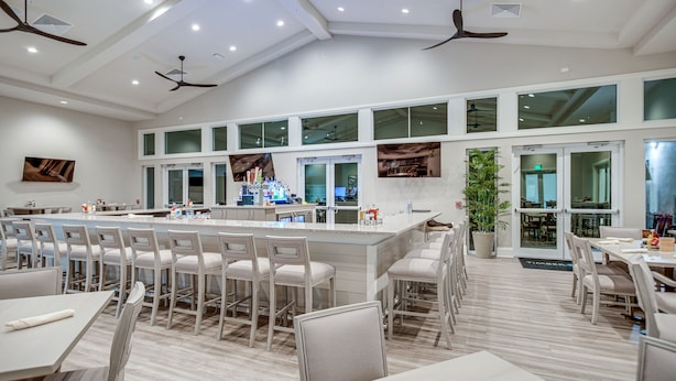 A modern restaurant with a long bar, multiple seating areas, and ceiling fans. - Fort Myers Oasis w/ Private Pool & Hot Tub! (Fort Myers)