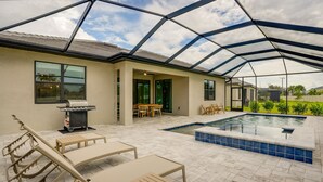 An outdoor patio with a pool, covered seating, and a grill area. - Fort Myers Oasis w/ Private Pool & Hot Tub! (Fort Myers)