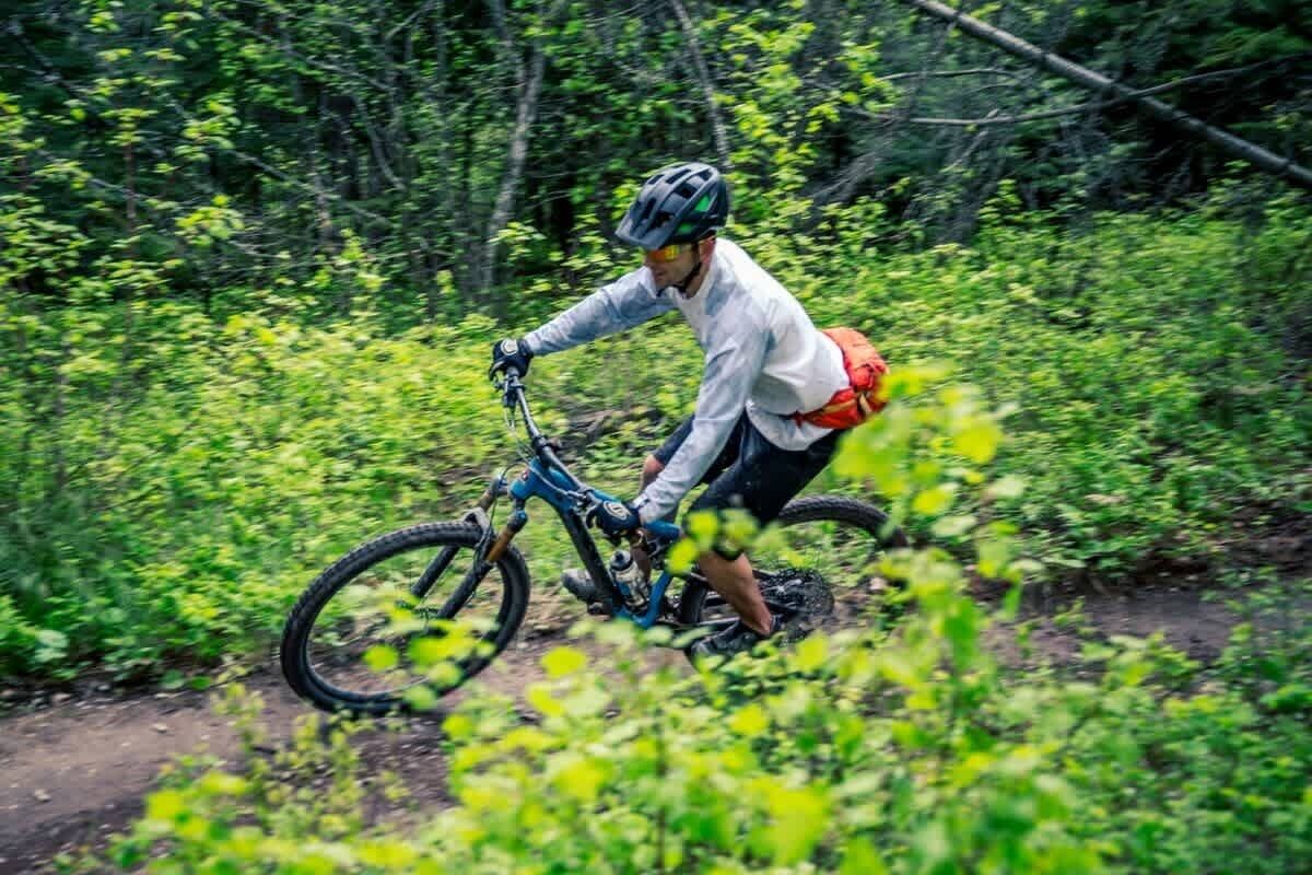 A person riding a mountain bike on a forest trail.