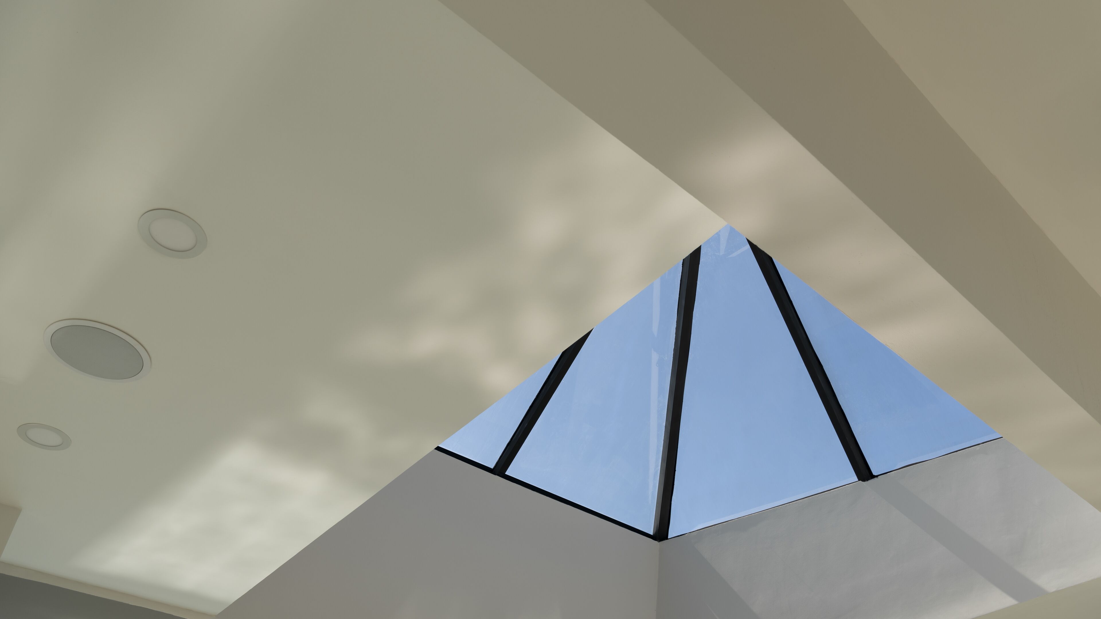 A modern interior with a geometric ceiling design and recessed lighting.