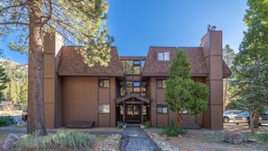 A modern building with a brick facade, a central entrance, and a paved driveway leading to the entrance. - Palisades Tahoe Condo~Walk to the Village~(#30) (Olympic Valley)