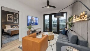 A modern living room with a grey sofa, a wooden coffee table, and a TV.
