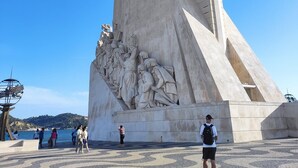 Un grand monument de pierre orné de sculptures complexes et surmonté d’une croix bien visible.