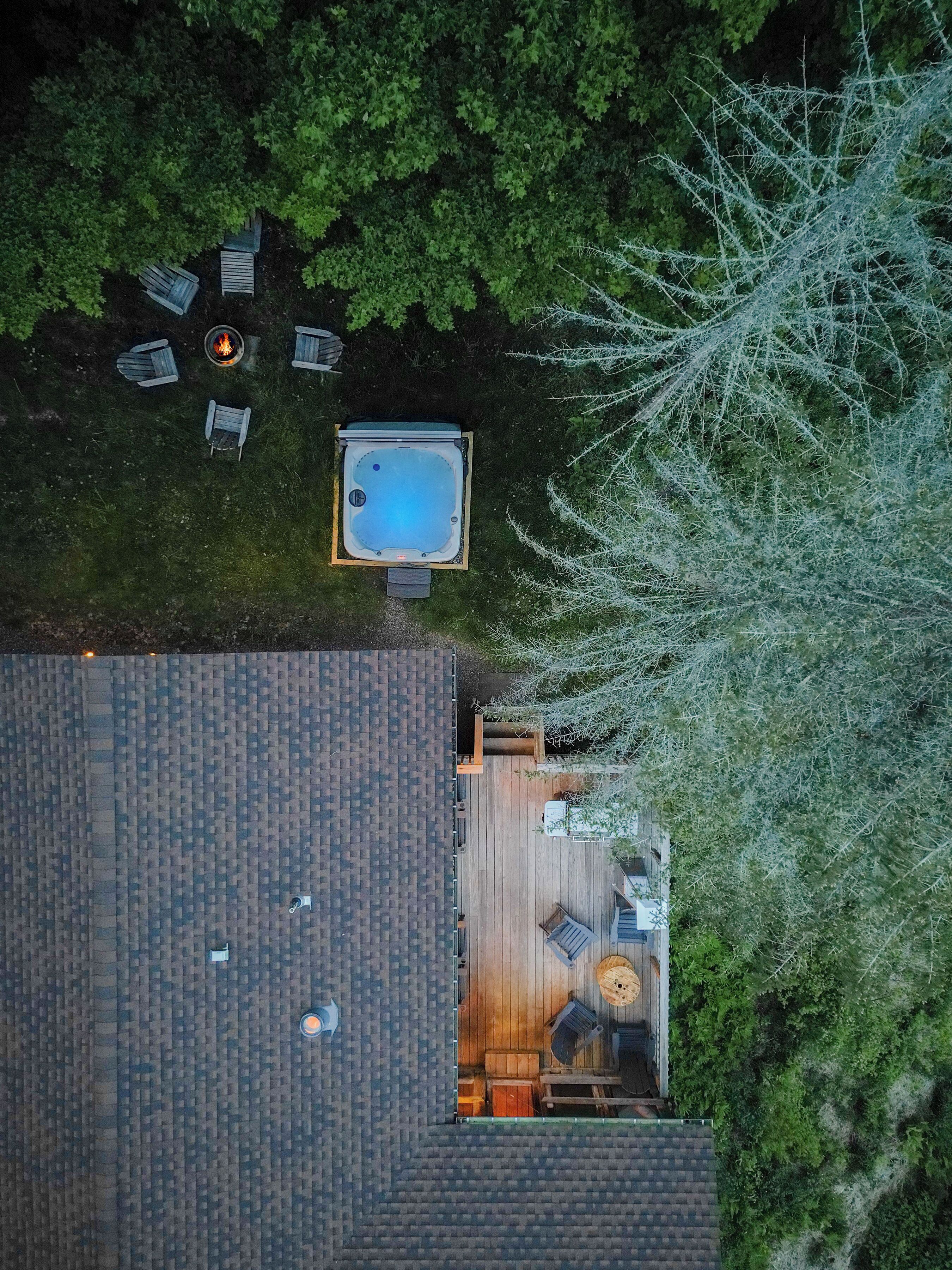An aerial view of a house with a swimming pool, deck, and outdoor seating area.