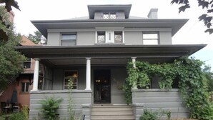 A two-story house with a front porch, a covered entryway, and a small front yard. - 2-Bedroom in the Heart of Denver (Denver)