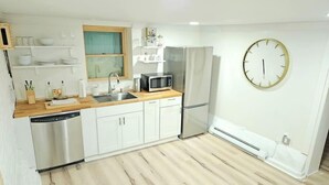 A modern kitchen with white cabinets, a stainless steel dishwasher, a microwave, and a refrigerator. - 2-Bedroom in the Heart of Denver (Denver)