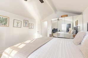 A bedroom with a large bed, a wardrobe, a mirror, and three framed botanical prints on the wall. - Spacious 4-bedroom suburban retreat in San Diego! Backyard, BBQ, Pool & Jacuzzi  (San Diego)