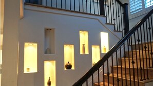 A staircase with a black railing and a series of illuminated wall sconces. - Spacious 4-bedroom suburban retreat in San Diego! Backyard, BBQ, Pool & Jacuzzi  (San Diego)