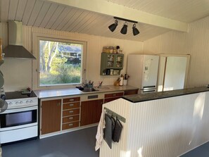 A kitchen with a stove, sink, and window.