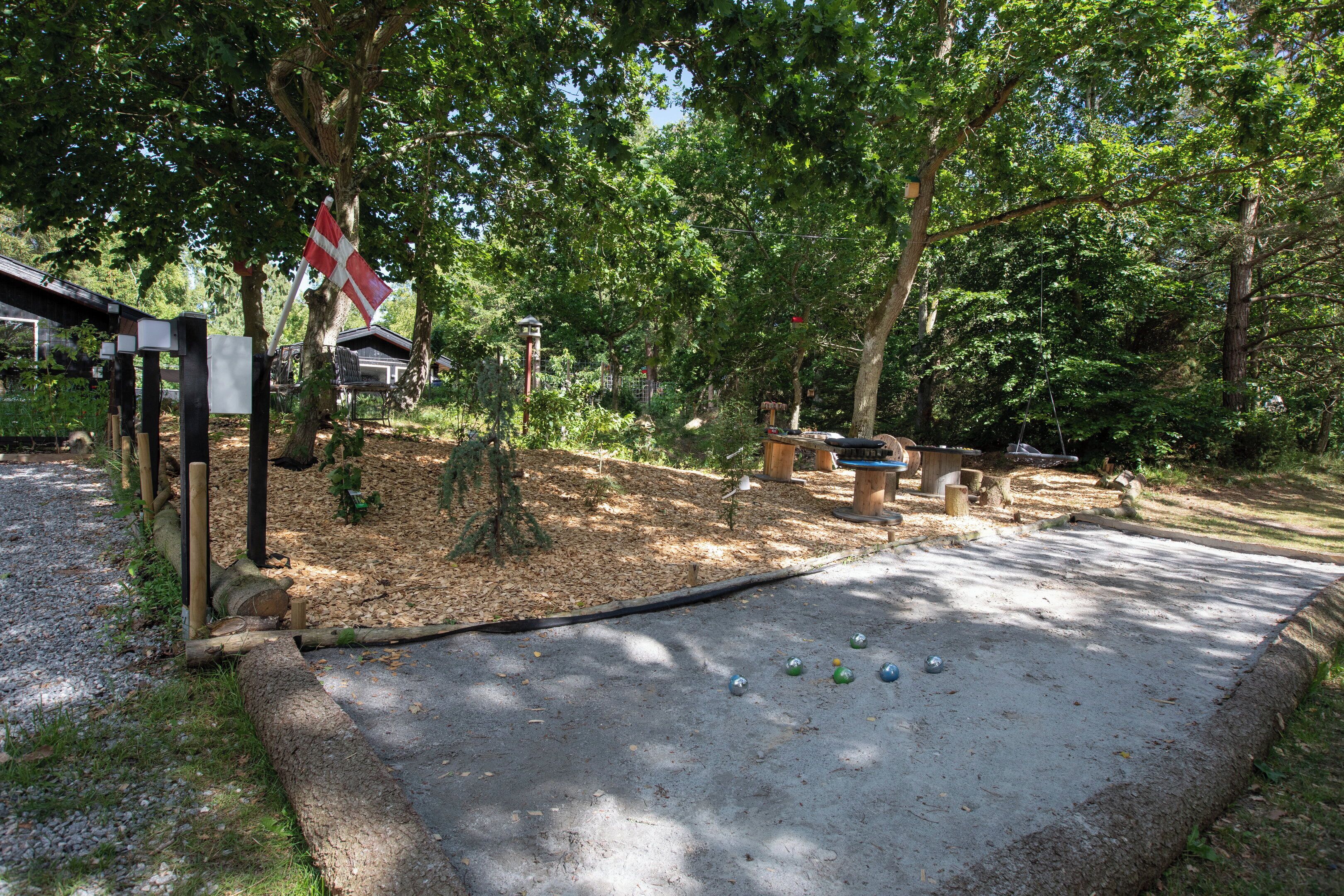 Un espace pique-nique équipé d’un mât avec un drapeau, de bancs et d’une table.