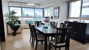 A modern dining area with a large table, chairs, and a potted plant. - Beautiful Apt, Best Location 2BR, Best Location (Panamá)