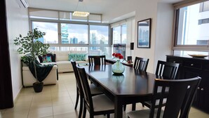 A modern dining area with a large table, chairs, and a potted plant. - Beautiful Apt, Best Location 2BR, Best Location (Panamá)