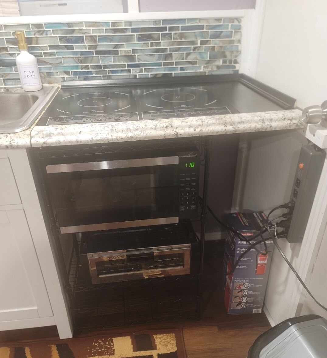 A kitchen with a built-in oven, a microwave, and a gas stove.