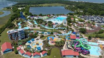 Vue aérienne d’un parc aquatique avec de nombreux toboggans, des piscines et un grand parking.