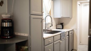 Une cuisine de taille réduite équipée d’une machine à café, d’un grille-pain et d’un évier.