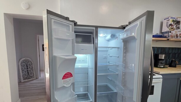 A modern kitchen with a built-in refrigerator, a stove, and a countertop with kitchen appliances.