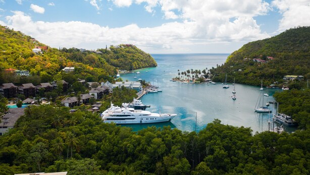 A coastal area with a marina, yachts, and buildings surrounded by lush greenery. - Villa in marigot bay. Breakfast inclusive. 2 mins walk to the beach (Castries)