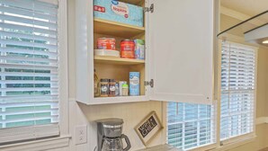 A kitchen with a cabinet containing various food items, a coffee maker, and a sign that says "WIFI + CHILL". - Family Fun near CHAS Summerville and Nexton (Summerville)
