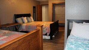 A bedroom with two beds, wooden headboards, and a quilted bedspread. - Brigham View (Barneveld)