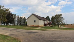 A single-story house with a gabled roof, a front porch, and a small deck. - Brigham View (Barneveld)