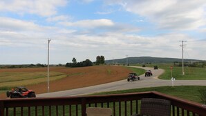 A rural road with vehicles, a stop sign, and power lines. - Brigham View (Barneveld)